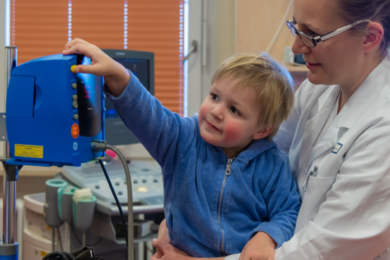 Das Bild zeigt ein Kind am Blutdruckmessgerät